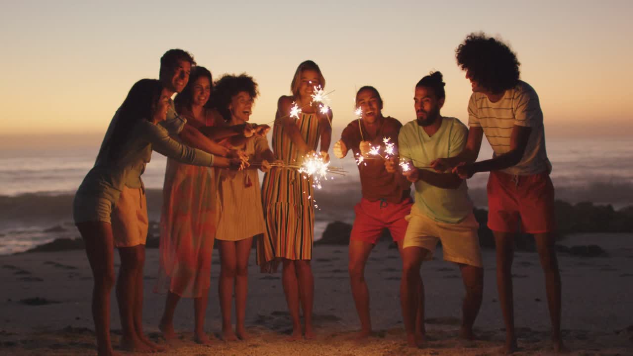 Amici che giocano con il fuoco in spiaggia