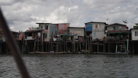 poor housing and living conditions along the river, illegal settlements, asian city slum