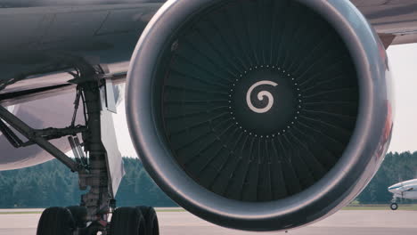 jet engine on a tarmac with planes in background