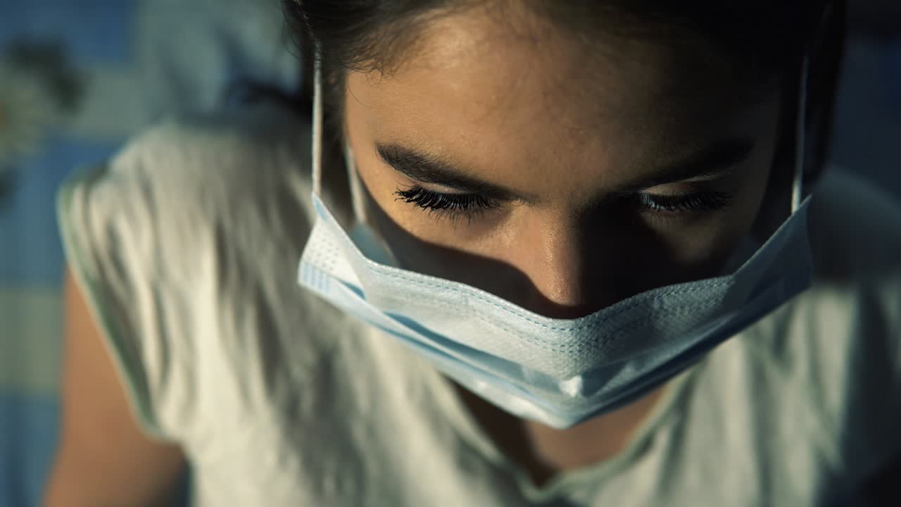 chica europea se cubre la cara con una máscara por la noche