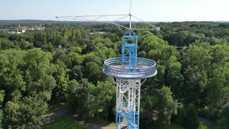 Toma-Aérea-De-La-Torre-De-Paracaídas-Azul-Y-Blanca-En-Un-Día-Soleado