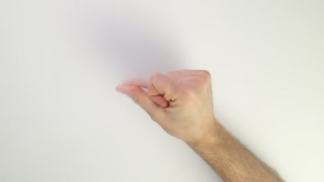 chasqueando los dedos sobre un fondo blanco. mano caucásica masculina aislado en la mesa. entrar en el ritmo. nervioso y golpear los dedos.
