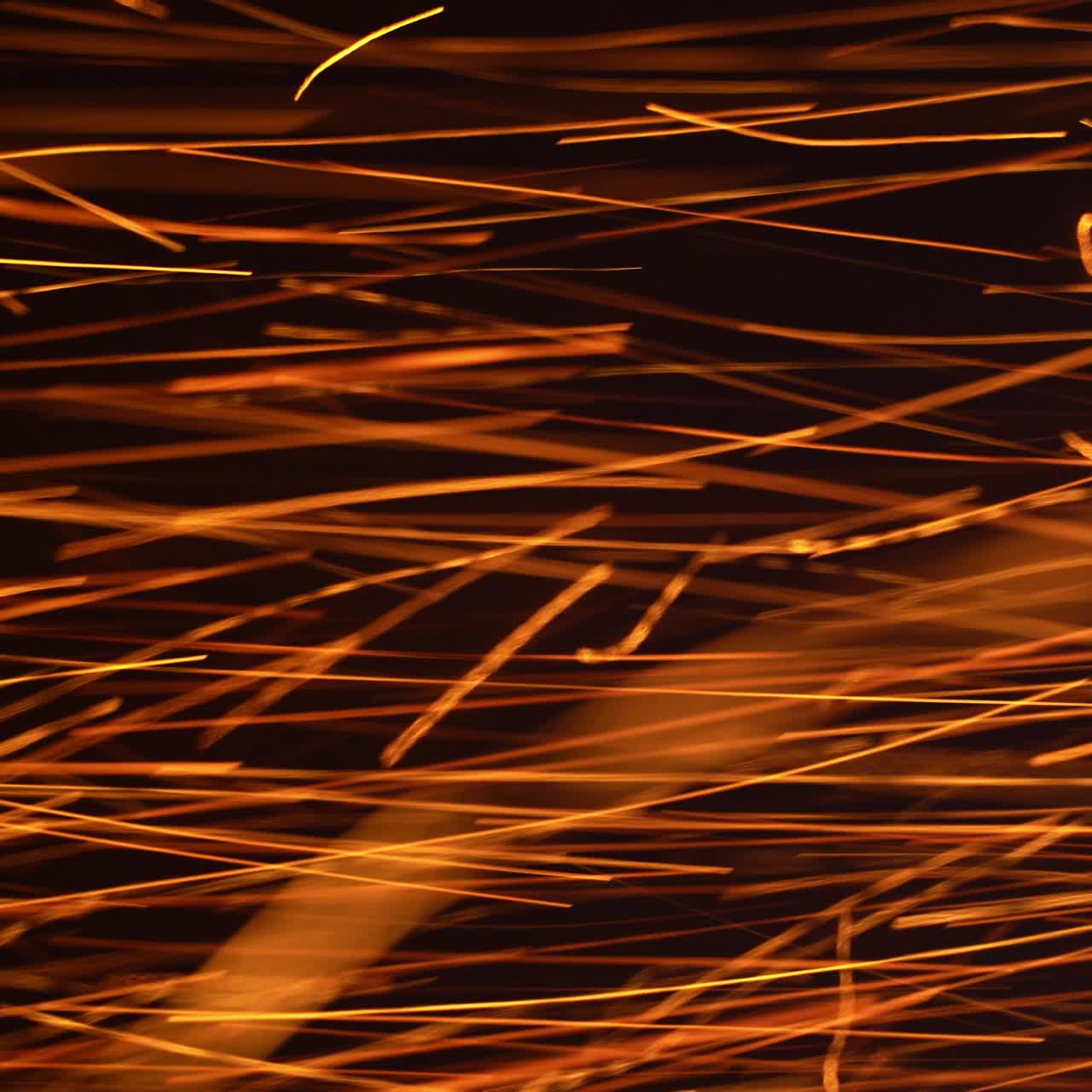 Lots of red hot sparkles alongside with white ones thrown at a very good speed. Bright ablaze particles at black backdrop