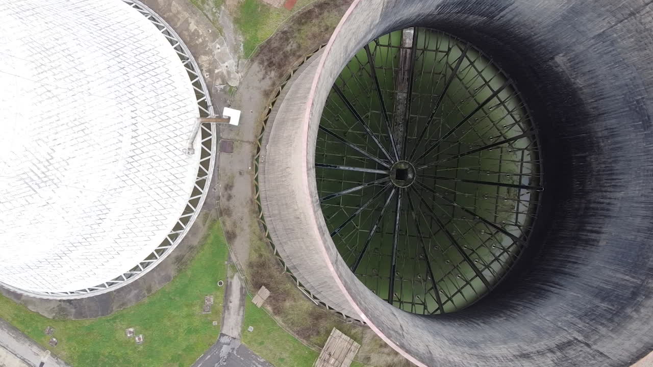 Panning aerial of two cooling towers at Santa Barbara power station. Cloudy day, Winter season. Cavriglia, San Giovanni Valdarno. Arezzo, Tuscany Italy