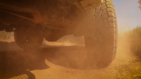 the rear wheels powertrain system of the 4 wheels off road drive light truck driving on dirt and dust ground