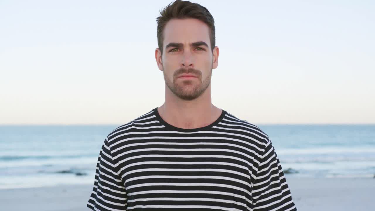 retrato de un joven de pie en una playa 4k