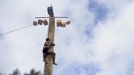 un homme grimpant sur un poteau lors d'un festival russe traditionnel