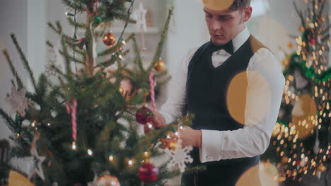 well dressed man decorating christmas tree at home