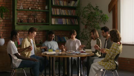 young adults praying in a library