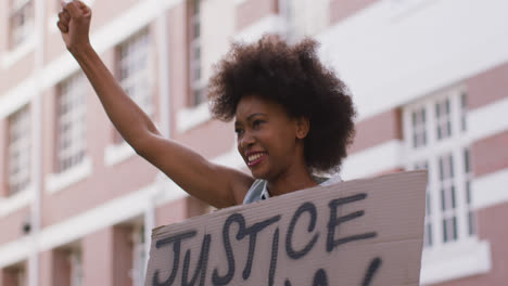 african american woman holding placard shouting raising fist during protest