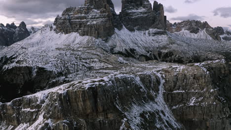 vista aérea inclinada hacia las montañas tre cime di lavaredo, noche nevada en las dolomitas, italia