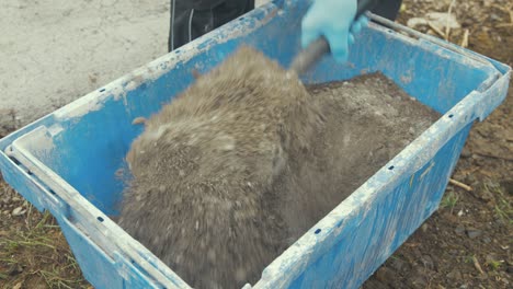 mixing dry cement, gravel and sand in bucket before adding water