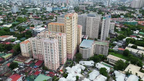 Orbiting-drone-shot-around-residential-towers-in-bustling-Manila,-Philippines