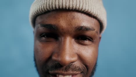 close-up portrait of a smiling man wearing a hat