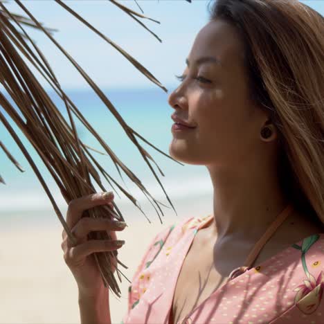 Delighted-woman-touching-palm-leaves