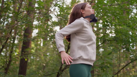 lady athlete jumps breathing deeply in forest. physical preparation for competitions in nature in sunny weather. active lifestyle and getting positive energy from training