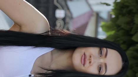 portrait of a young woman with long dark hair outdoors