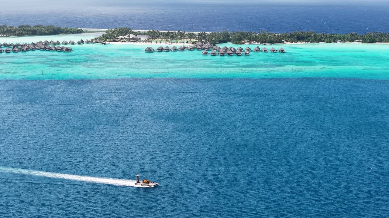Bora Bora, French Polynesia. Drone Shot of Boat in Lagoon and Exclusive Luxury Tropical Resort on Motu Island