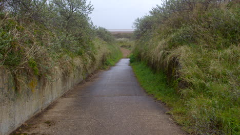 Mid-shot-of-a-old-military-concrete-road-going-down-to-the-beach-at-Theddlethorpe,-Dunes,-National-Nature-Reserve-at-Saltfleetby