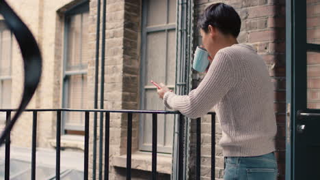 beautiful asian woman using smart phone outside drinking coffee on a break