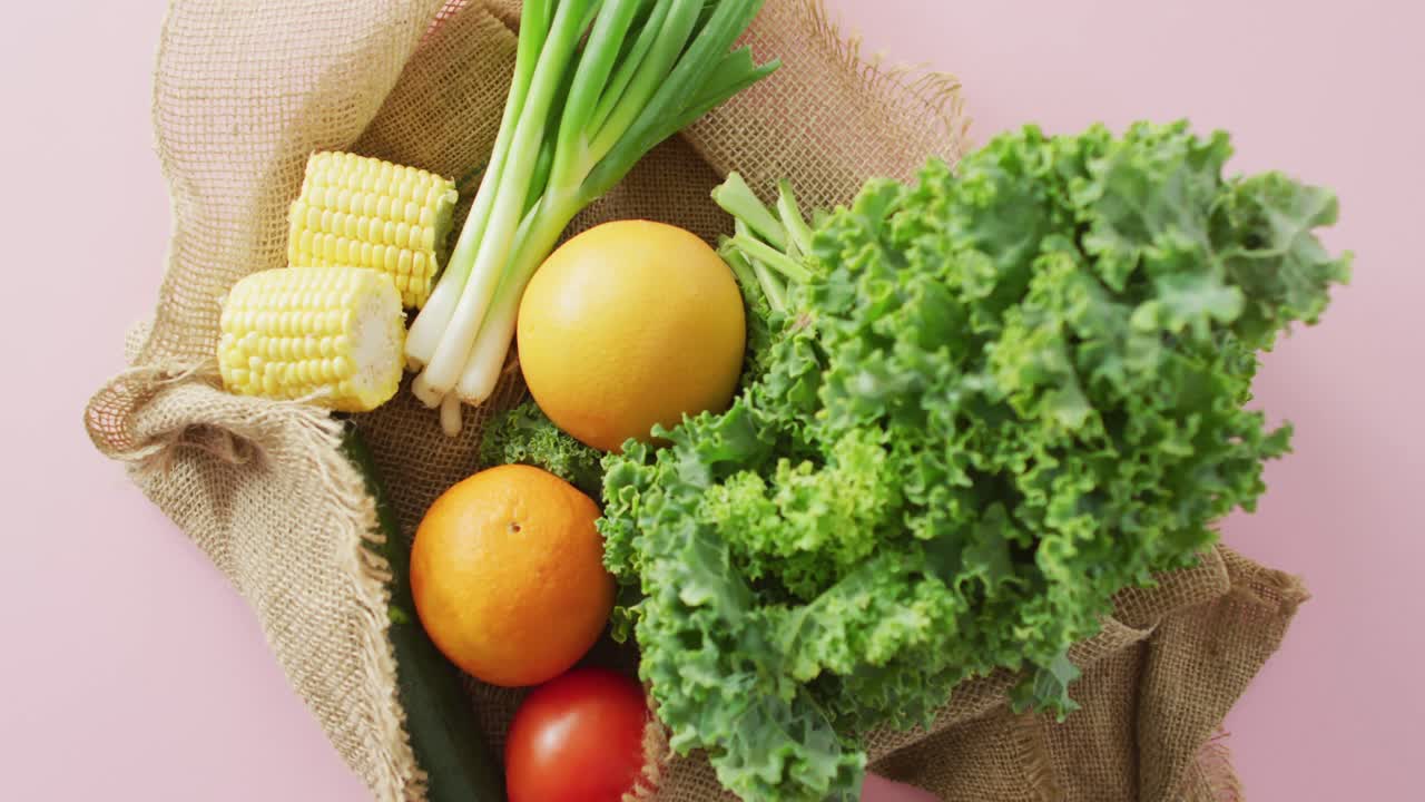 핑크색 배경 에 있는 시골 가방 에 신선 한 과일 과 채소 의 비디오