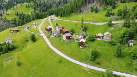 Wide drone shot reveals peaceful rural village nestled in lush Italian hills