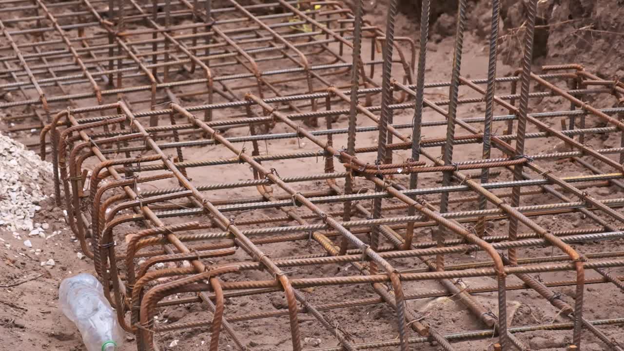 Large steel cages as reinforcement for a footing foundation on a construction site