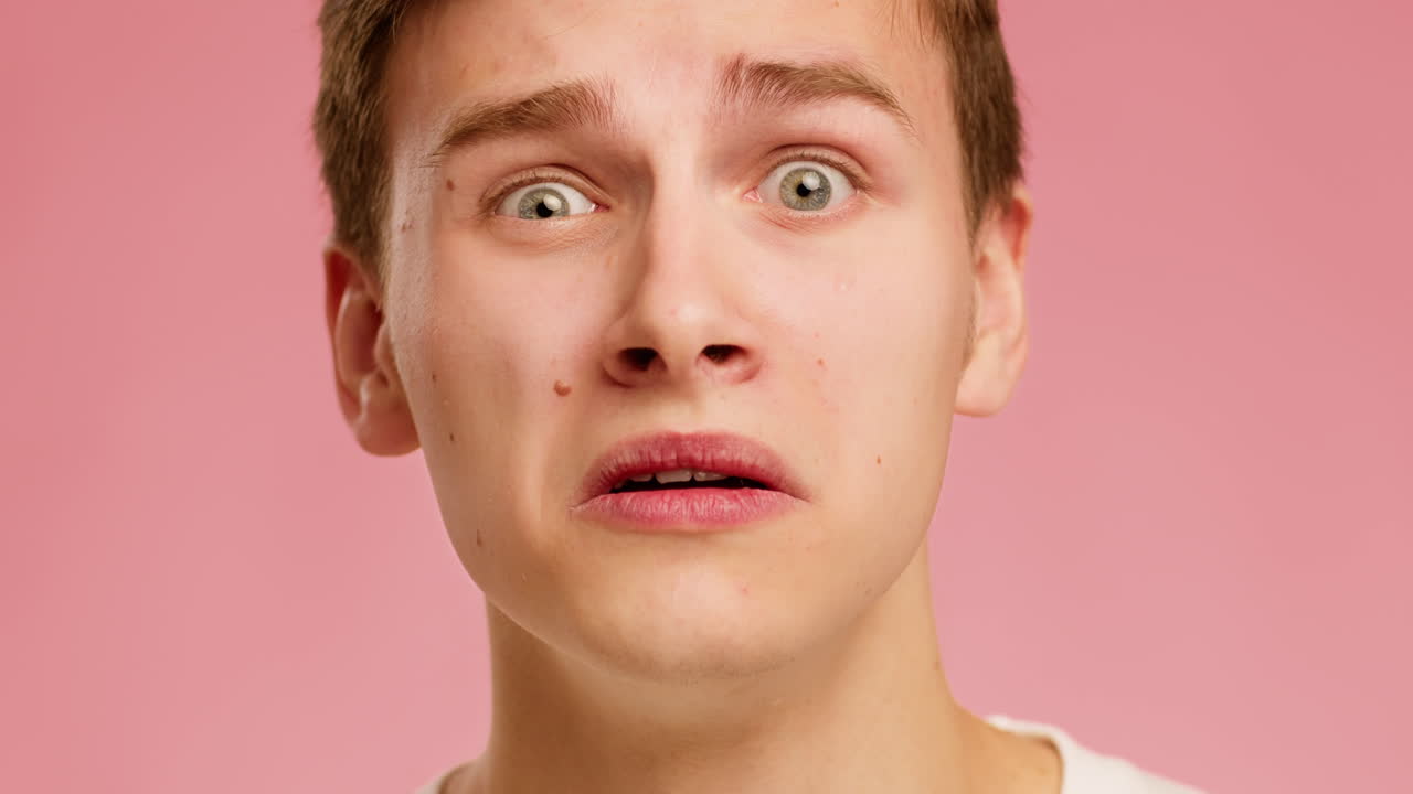 Close-up of a young man expressing sadness and confusion.
