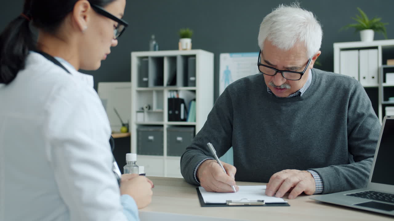 el médico discutiendo formularios médicos con el paciente