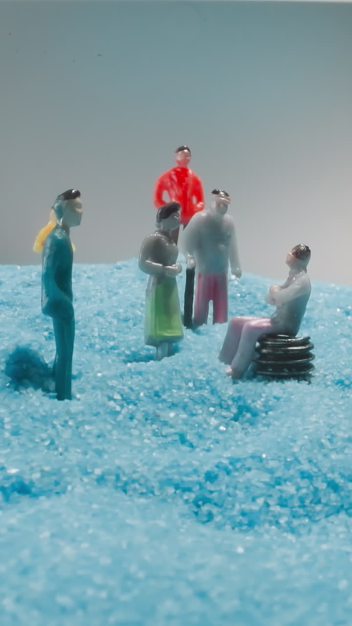Figures of family members talking and enjoying time together. Man sitting on bench while people standing on blue sand shimmering under grey sky macro