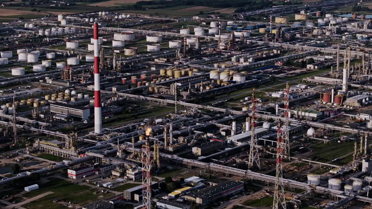 Aerial view of industrial refinery showing fuel tanks pipes and smoke stacks