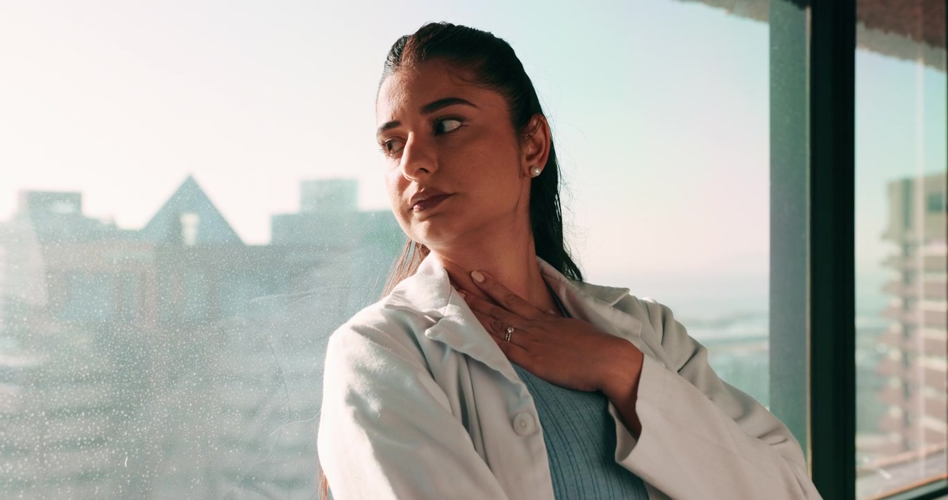 Pensive Young Woman Looking Out of Office Window