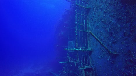 bucear a lo largo de un naufragio que yace de lado bajo el agua en el mar rojo