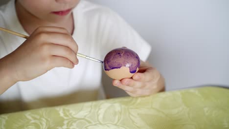 a boy paints easter eggs and prepares to celebrate easter 02