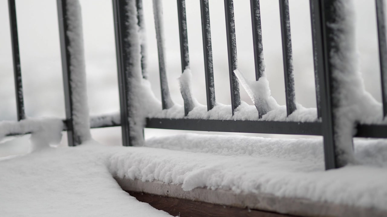 Close-up of Snow and Icicles on a Metal Balcony Railing