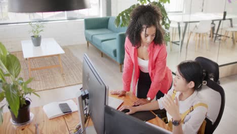 Busy-diverse-casual-businesswomen-using-computer-and-discussing-work-in-office,-slow-motion