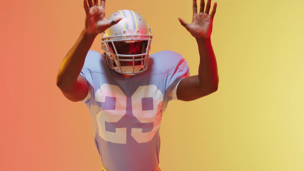 Video di un giocatore di football americano afroamericano su sfondo giallo-arancione.