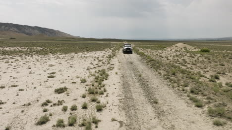 jeep standing on dirt road in arid steppe plain in vashlovani, georgia