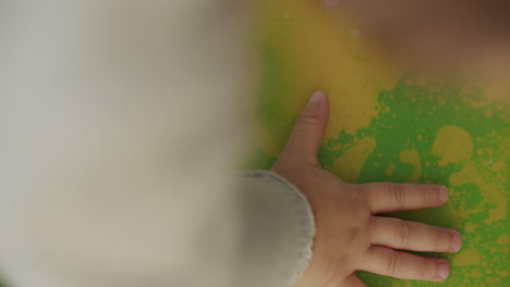 top shot of a toddler and adult playing with a sensory matte