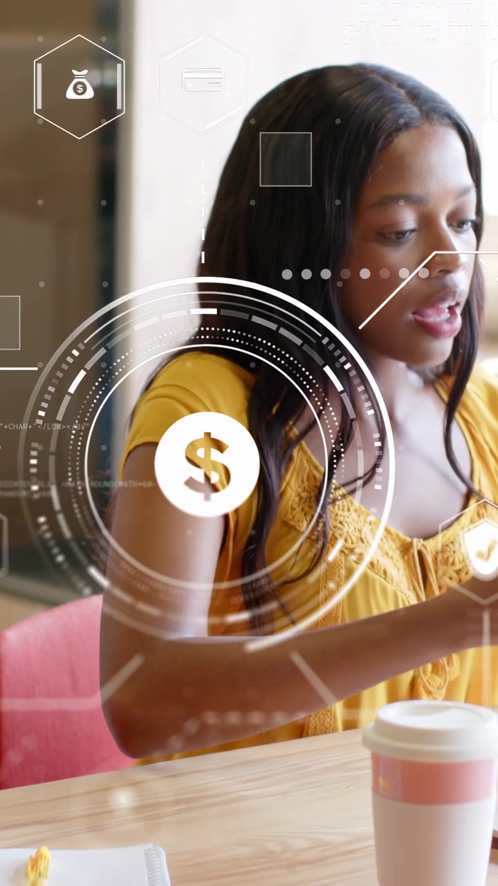 Vertical video: Woman at cafe table tapping device, budgeting while HUD $ pulsing over forearm