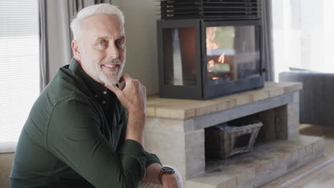 portrait of middle aged happy caucasian man sitting in living room at home with copy space