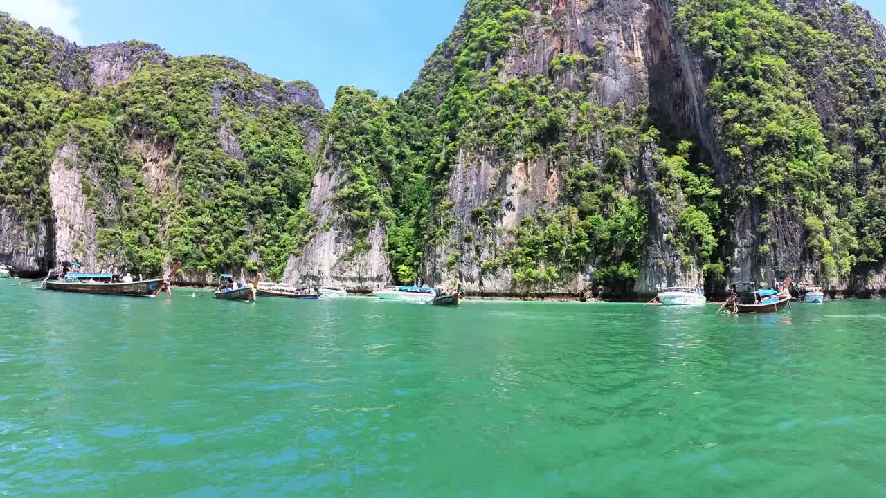 Thuyền đuôi dài lướt trên vịnh Phang Nga vào một ngày nắng, để lộ làn nước màu ngọc lục bảo