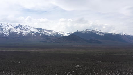 Montaña-Del-Cráter-Cubierta-De-Nieve-Y-Colinas-Eólicas-Vistas-Desde-La-Autopista-395-En-California