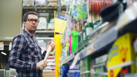 hombre mirando un bate de béisbol en una tienda