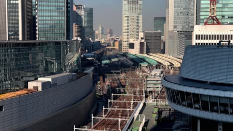 cityscape with modern architecture, clear skies, and train station, daytime, urban vibe, aerial shot