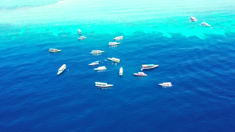 maldivas océano azul profundo que muestra barcos en medio flotando sobre la superficie del agua - toma aérea
