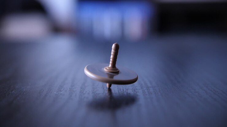 Close-up of a Spinning Top Toy on a Dark Surface