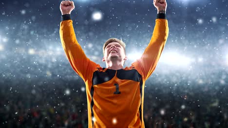 goalkeeper celebrates a victory and raises arms happily on the professional stadium while it is snowing