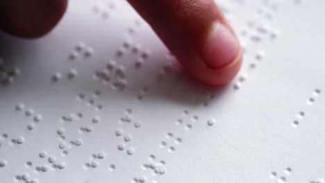 school kid reading a braille book in classroom at school