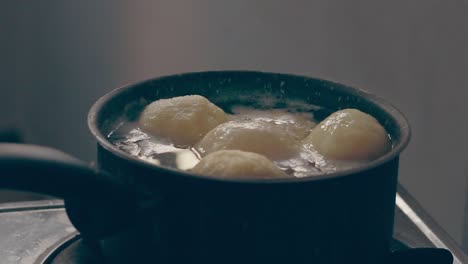 ambient motion of traditional german potato dumplings or kartoffelklöße bobbing in a pot showing candid daily home life and classic winter comfort food